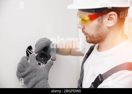 Electrician builder install working switches and sockets black color loft style Stock Photo