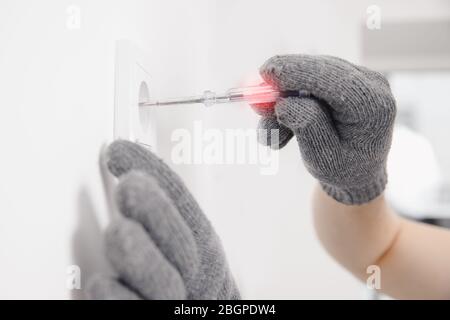 Electrician checks device for electricity voltage power outlet sockets Stock Photo