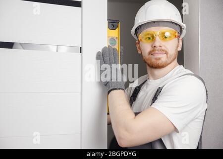 Carpenter worker installation process of wood door hinge tool level Stock Photo