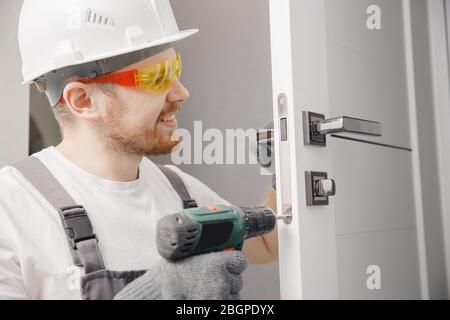 Carpenter worker installation process of wood door hinge Stock Photo