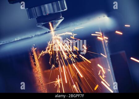 CNC laser machine cutting sheet metal with light spark. Technology plasma industrial, Blue steel color Stock Photo