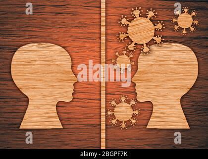 The silhouette of a human head, the virus on a brown wooden background. The epidemic of the coronavirus, pandemic. Stock Photo