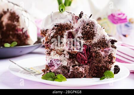 Chocolate cake with cherries and  cream on light background. Stock Photo