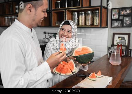 man and muslim woman having some fruit for break fasting dinner Stock Photo