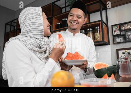 man and muslim woman having some fruit for break fasting dinner Stock Photo