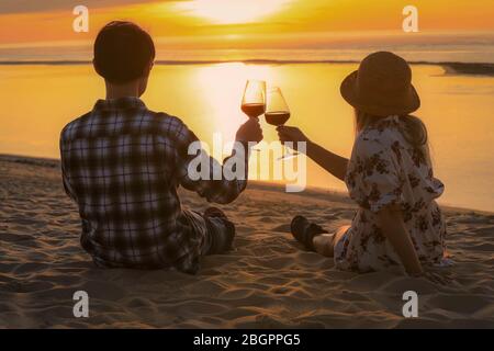 Couple celebration drinking red wine at sunset beach Stock Photo