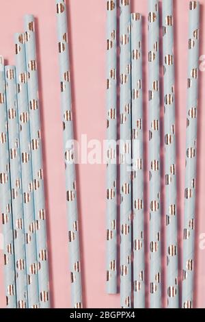 Background paper tubes ,Closeup of drinking blue straws for party, Top view of blue paper disposable eco-friendly straws for summer cocktails on pink Stock Photo