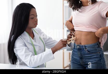 Dietary doctor checking body fat index with caliper Stock Photo