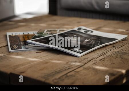 A stack of magazines laid out on a wooden coffee table Stock Photo