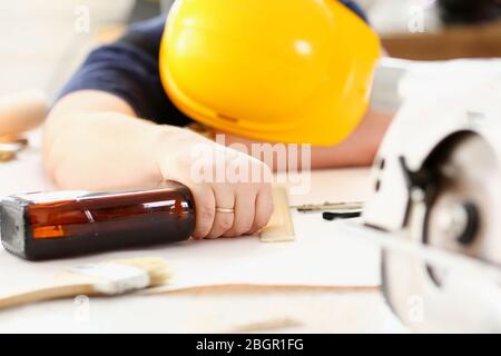 Arm of drunken worker in yellow helmet Stock Photo
