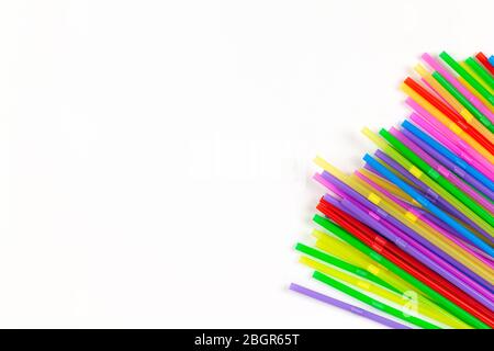 Disposable plastic multicolored tubules for drinks located in right corner of image on white background, copy space. Festive concept, party, birthday. Stock Photo