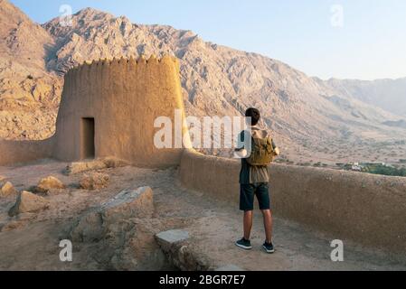 Traveler exploring Dhayah Fort in north Ras Al Khaimah United Arab Emirates and enjoying at sunset view Stock Photo