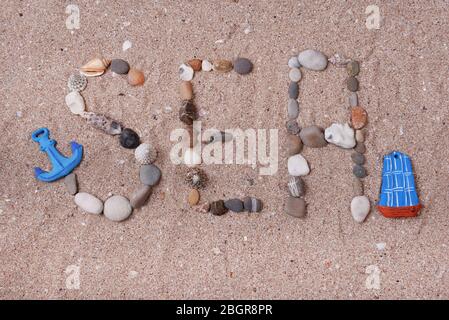 Word sea made from sea shells and stones on sand Stock Photo