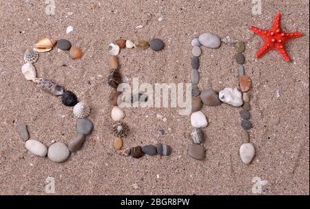 Word sea made from sea shells and stones on sand Stock Photo