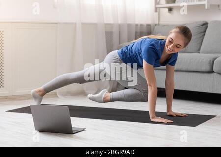 Young sporty woman training with coach online, free space Stock Photo
