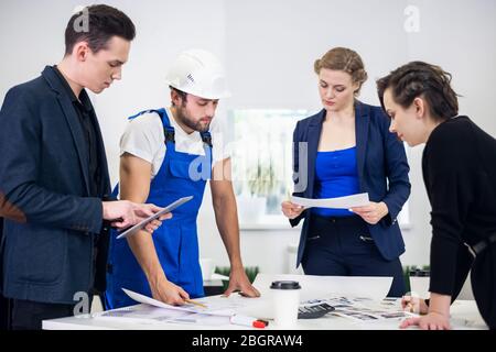 Team of architects going over blueprints in the office. Stock Photo