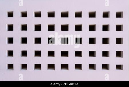White painted wooden wall with square holes Stock Photo