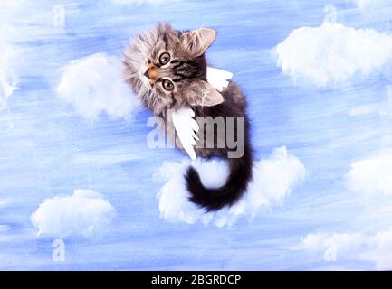Beautiful kitten with paper wings, on bright background Stock Photo