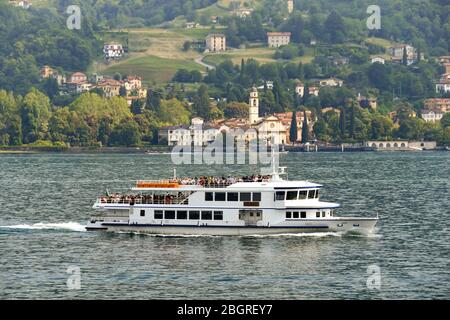 CADENABBIA, LAKE COMO - JUNE 2019: Small passenger ferry with people on board crossing Lake Como near Cadenabbia Stock Photo