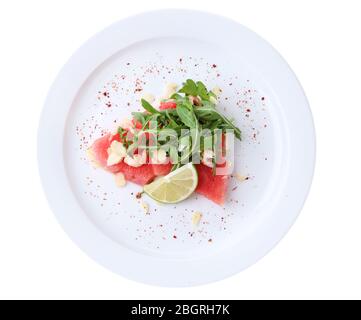 Salad with watermelon, feta, arugula, shrimps, balsamic sauce  on plate, isolated on white Stock Photo