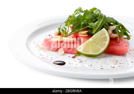 Salad with watermelon, feta, arugula, shrimps, balsamic sauce  on plate, isolated on white Stock Photo
