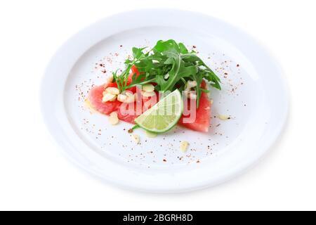 Salad with watermelon, feta, arugula, shrimps, balsamic sauce  on plate, isolated on white Stock Photo