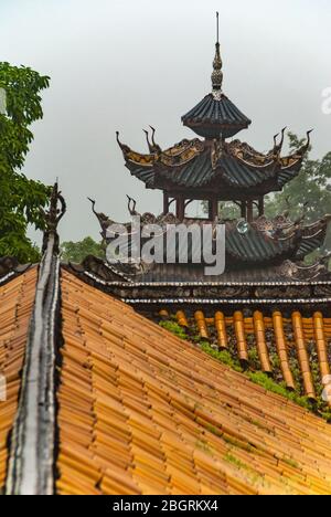 Fengdu, China - May 8, 2010: Ghost City, historic sanctuary. Pagoda style and Yellow Chinese architectural roof structure with green foliage and silve Stock Photo