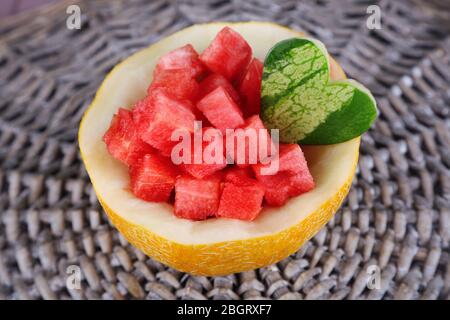 Slices of watermelon in melon bowl on wicker mat Stock Photo