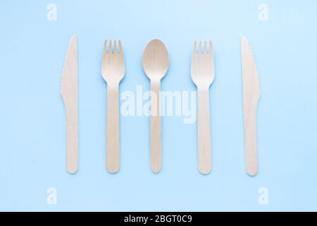 eco friendly disposable kitchenware utensils on blue background. wooden forks and spoons. ecology, zero waste concept. top view. flat lay Stock Photo