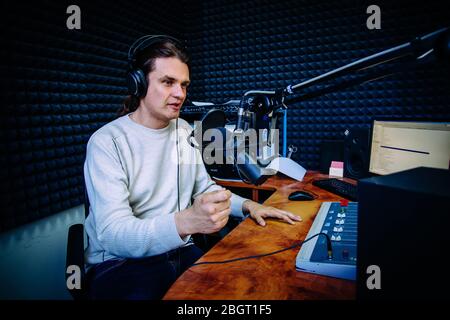 Talking male radio presenter in radio station. Stock Photo