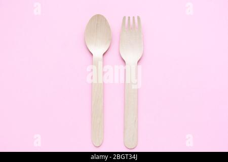 eco friendly disposable kitchenware utensils on pink background. wooden forks and spoons. ecology, zero waste concept. top view. flat lay Stock Photo