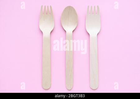 eco friendly disposable kitchenware utensils on pink background. wooden forks and spoons. ecology, zero waste concept. top view. flat lay Stock Photo
