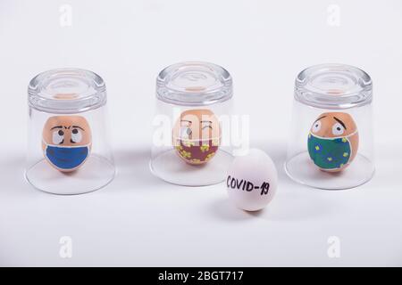 The concept of quarantine at Easter time. Easter  painted eggs in glass cups, a message about the quarantine due to the Covid-19 coronavirus pandemic Stock Photo