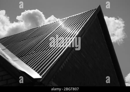 Roof made of stainless steel against the sky with clouds, bw photo. Stock Photo