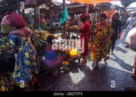 Shoppers move through narrow aisles at Kisangani's central market in Democratic Republic of Congo. Local authorities say there is little they can do to prevent the spread of the coronavirus at the market. (Francoise Mbuyi, GPJ Democratic Republic of the Congo) Stock Photo