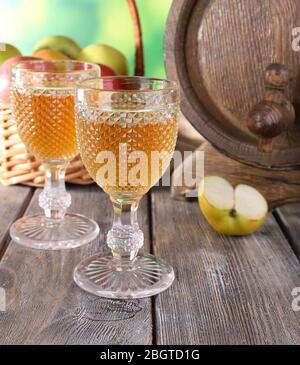 Still life with tasty apple cider and fresh apples, on nature background Stock Photo