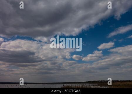 Cloudy dramatic sky with a narrow strip of horizon below. Creative vintage background. Stock Photo