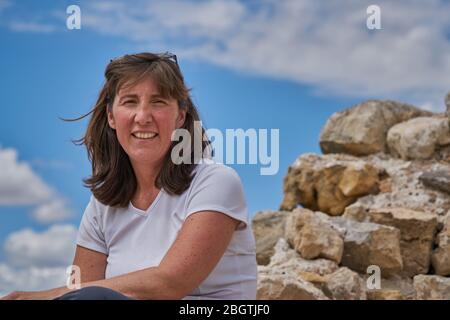 Thoughtful Woman Sitting On Rock Stock Photo