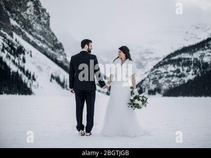 bride and groom wedding on ice in winter Lake Louise, Alberta, Canada Stock Photo