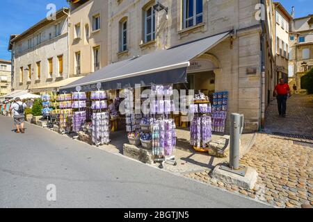 Tourists walk by a gift shop selling Lavender products on the sidewalk in the Provence region of Avignon France Stock Photo