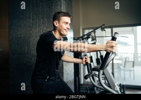 Young man doing fitness exercises on stepper at home gym.Making an effort and training for fit body shape,weight loss.Excess body weight.Home workout. Stock Photo