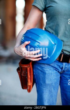 Close up of a female construction worker holding a hard hat Stock Photo