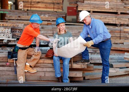 Group of construction workers looking over plans Stock Photo