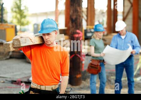 Portrait of male construction worker with two construction worke Stock Photo