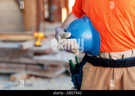Close up of a male construction worker holding a hard hat Stock Photo