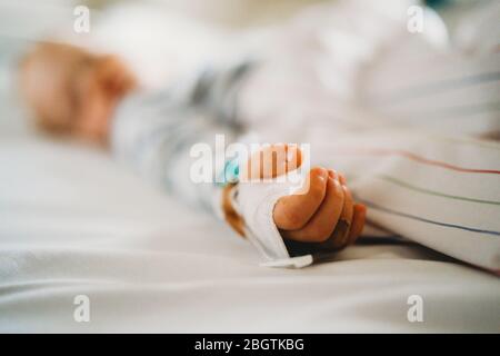 Baby child hand with IV sick at the hospital with a virus coronavirus Stock Photo