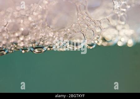 Red detergent bubbles in macro view Stock Photo