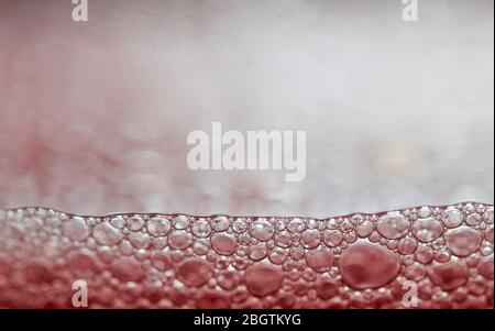 Red detergent bubbles in macro view Stock Photo