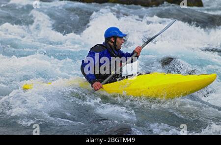 Man going on his white water kayak  rapids in an Icelandic river Stock Photo