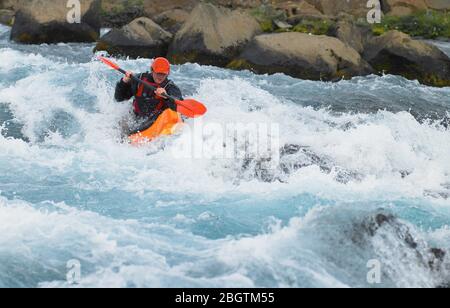 Man going on his white water kayak  rapids in an Icelandic river Stock Photo